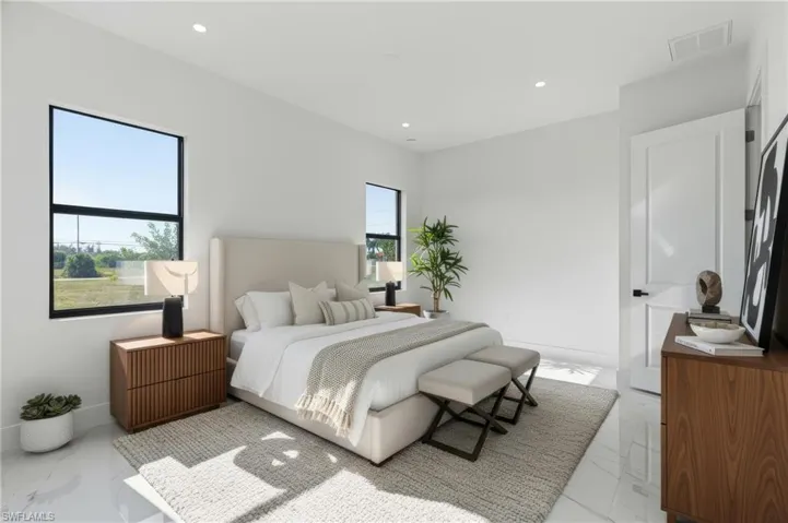 Bedroom with multiple windows, light marble finish floors, and recessed lighting