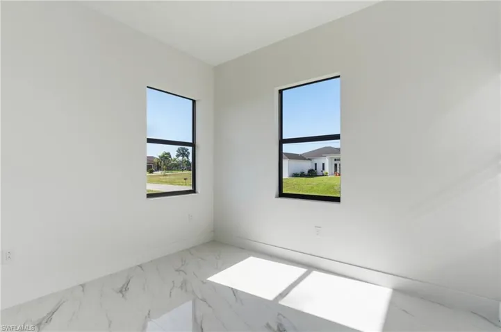 Spare room with marble finish floors and baseboards
