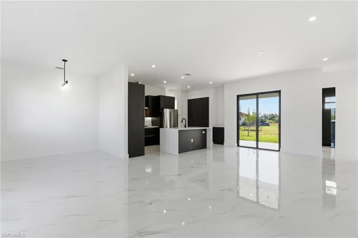 Unfurnished living room with light marble finish flooring and recessed lighting