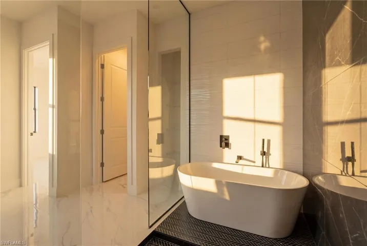 Bathroom with a freestanding tub and marble tiled flooring