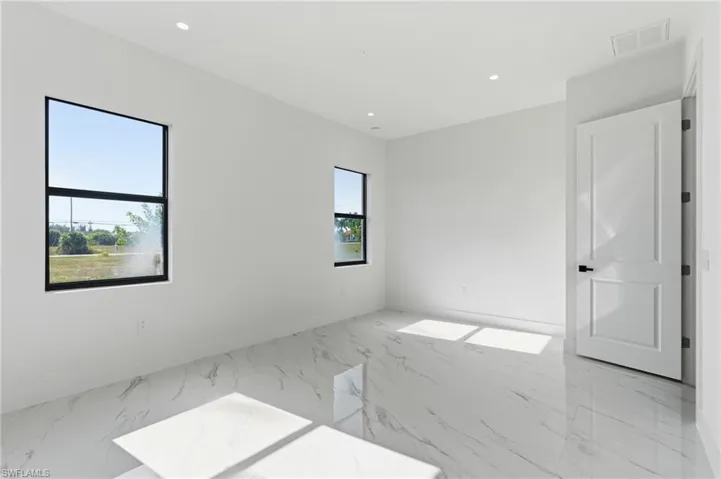Spare room with light marble finish floors and recessed lighting