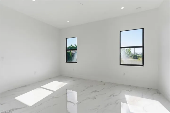 Unfurnished room with light marble finish flooring and recessed lighting