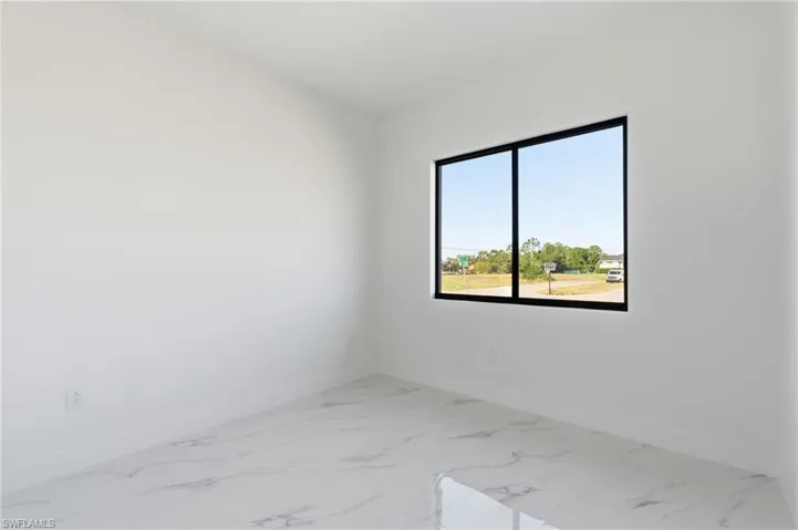 Unfurnished room featuring baseboards and light marble finish flooring