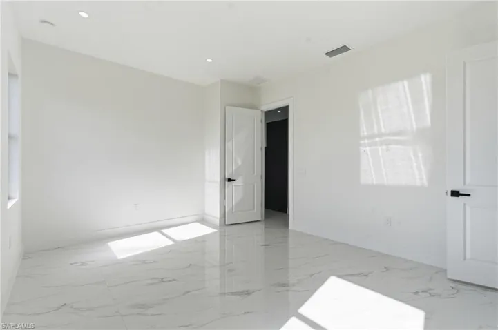 Unfurnished bedroom featuring light marble finish flooring and baseboards