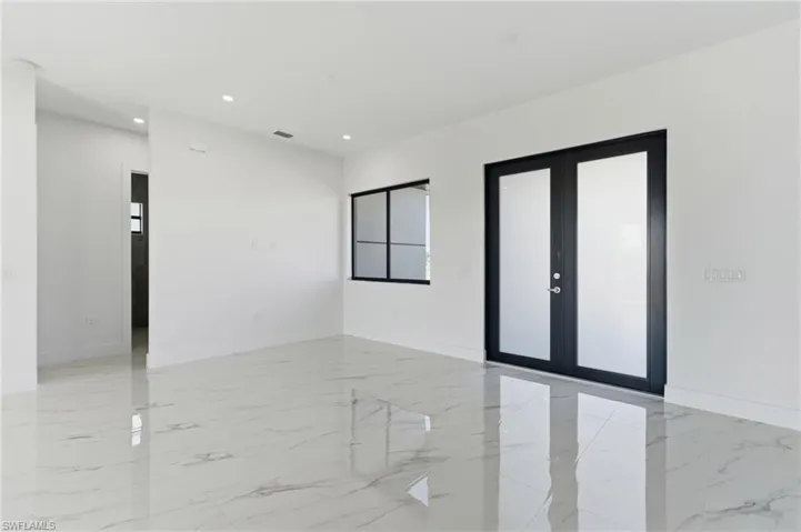 Empty room featuring light marble finish flooring, french doors, and recessed lighting