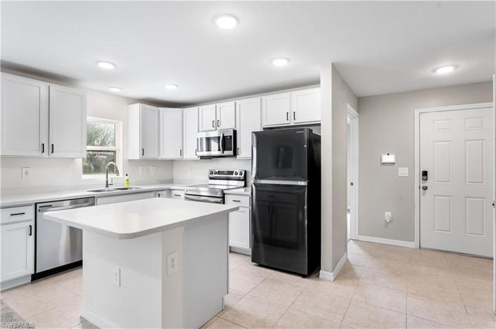 bright white kitchen and foyer on left