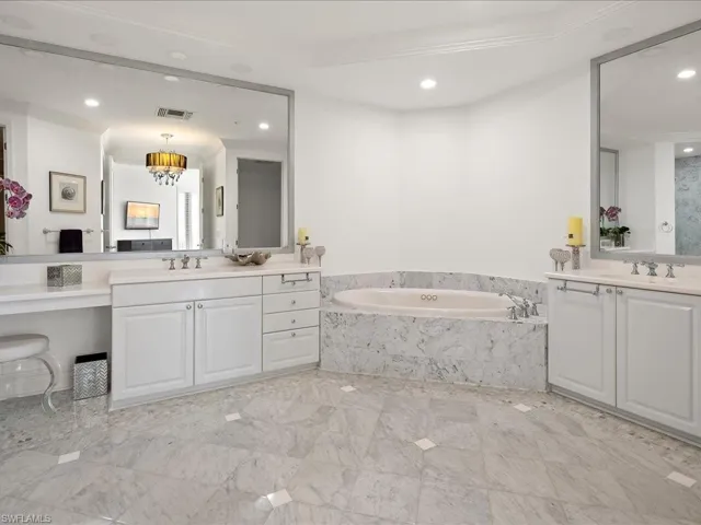 Full bath with two vanities, a garden tub, and recessed lighting