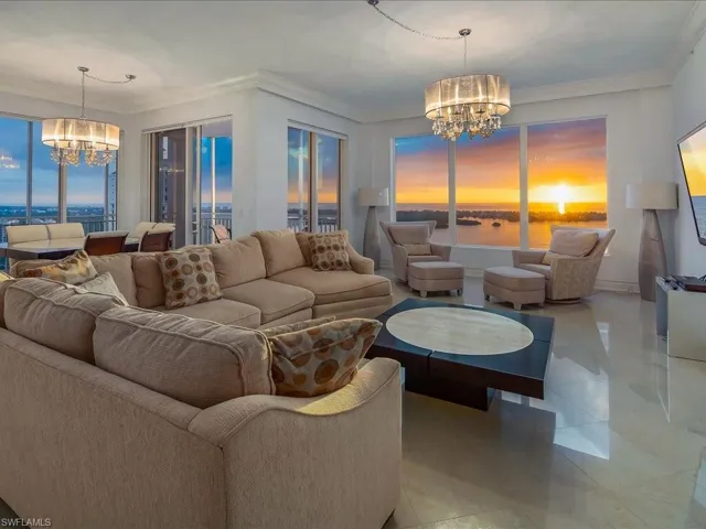 Living area featuring a chandelier, crown molding, and tile patterned floors
