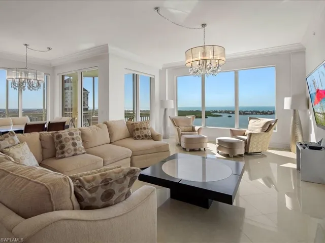Tiled living room with a chandelier and ornamental molding