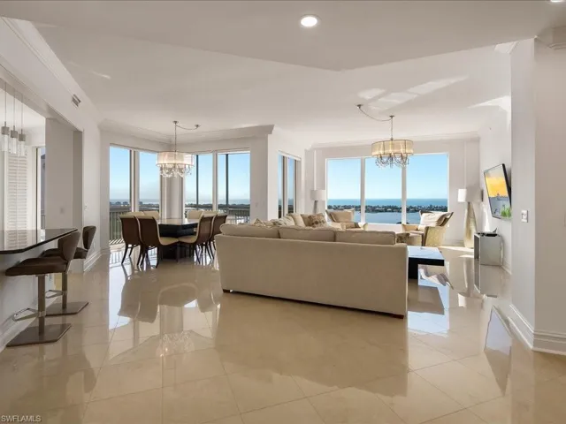 Living room with a chandelier, healthy amount of natural light, recessed lighting, and ornamental molding