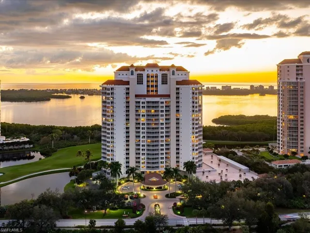 Property at dusk with a water view and a view of apartment building / complex
