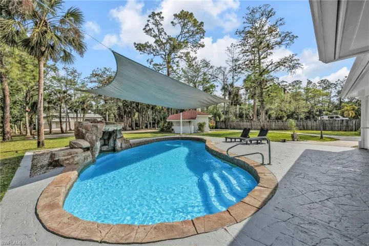 View of pool with patio surround and an outbuilding