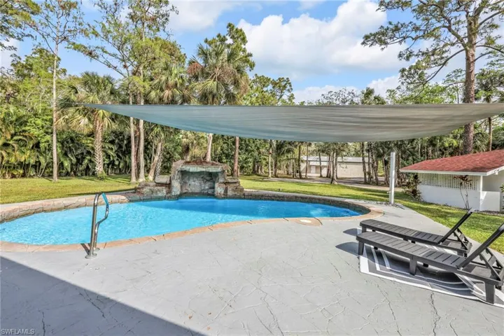 Swimming pool with a yard and a patio area