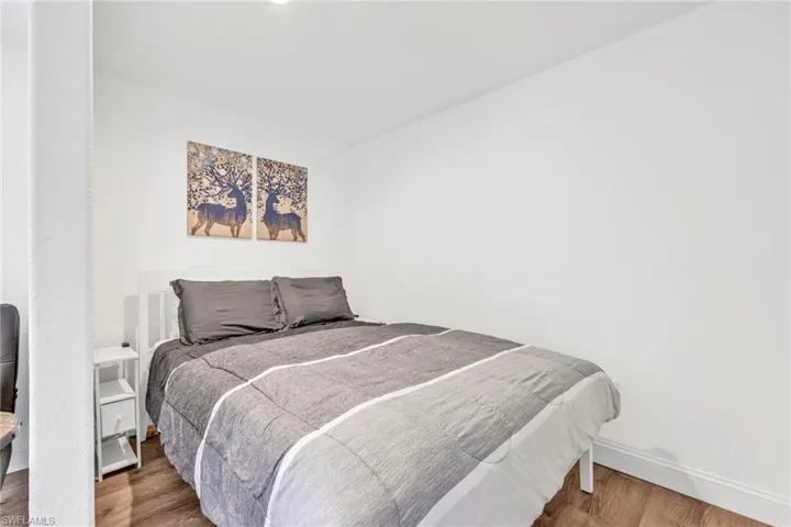 Bedroom with wood finished floors and baseboards