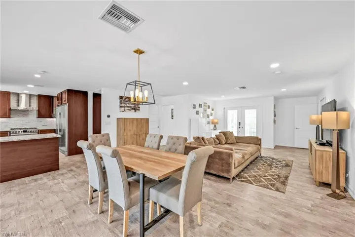 Dining area featuring light wood finished floors, french doors, and hanging lights