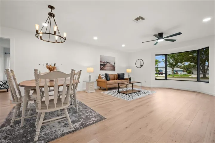 Dining space featuring light hardwood / wood-style flooring and ceiling fan with notable chandelier