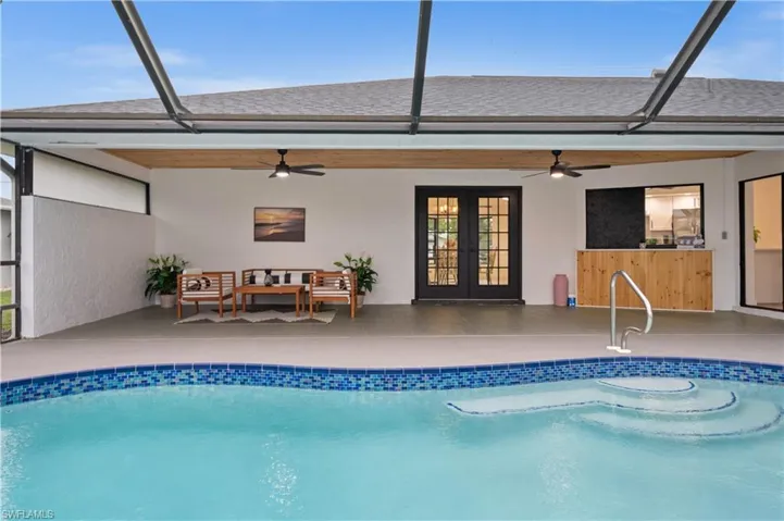 View of swimming pool with outdoor lounge area, glass enclosure, french doors, ceiling fan, and a patio