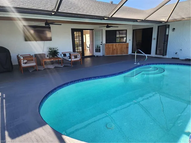 View of swimming pool with a lanai, a patio area, ceiling fan, and area for grilling
