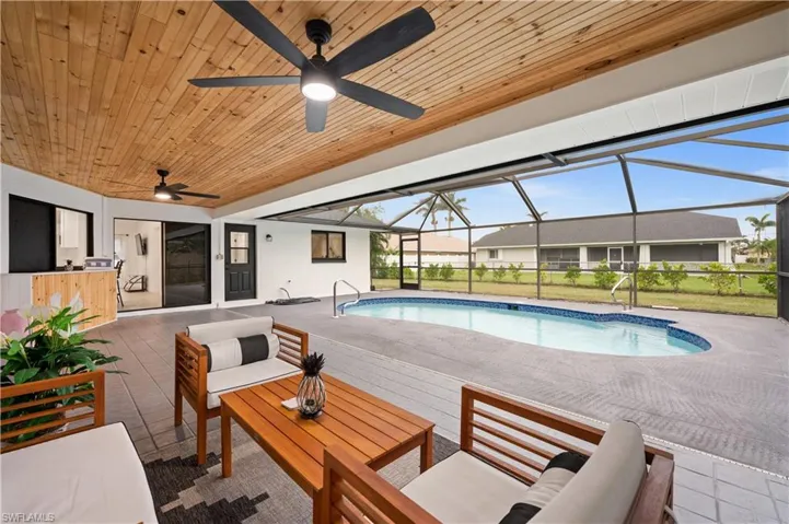 View of pool featuring outdoor lounge area, a patio area, and a lanai