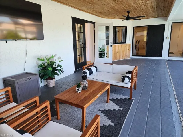 Wooden terrace with an outdoor living space, ceiling fan, and a patio