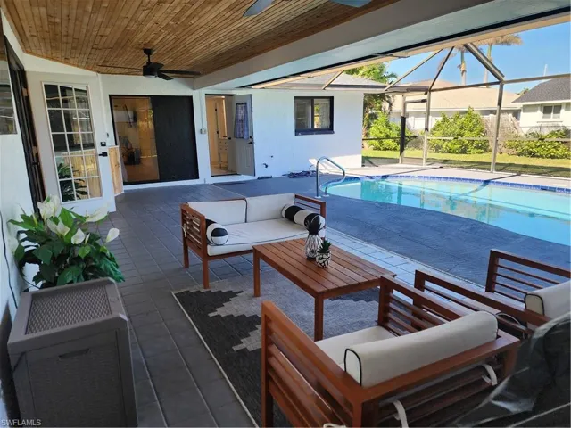 View of pool featuring a lanai, an outdoor living space, ceiling fan, and a patio