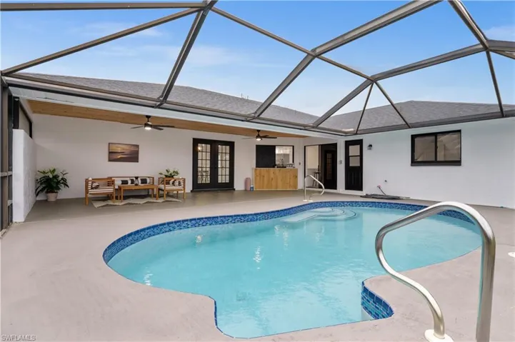 View of pool featuring an outdoor living space, french doors, ceiling fan, a lanai, and a patio
