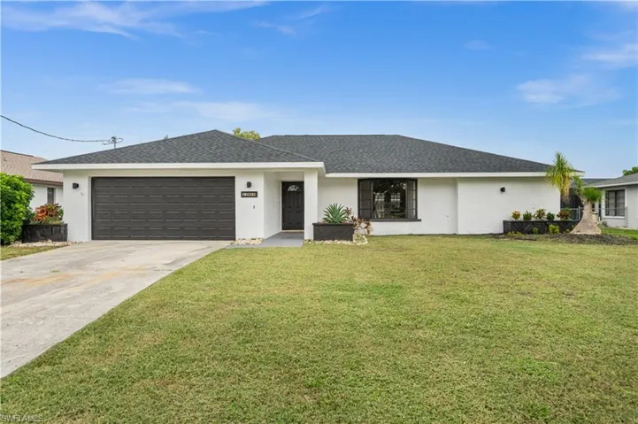 Ranch-style home with a garage and a front lawn