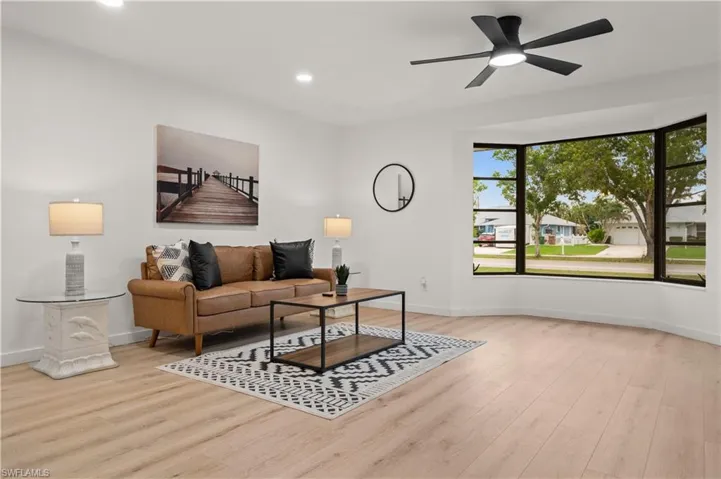 Living room with light wood-type flooring and ceiling fan
