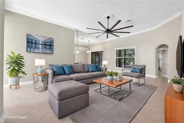 Tiled living room with crown molding and ceiling fan