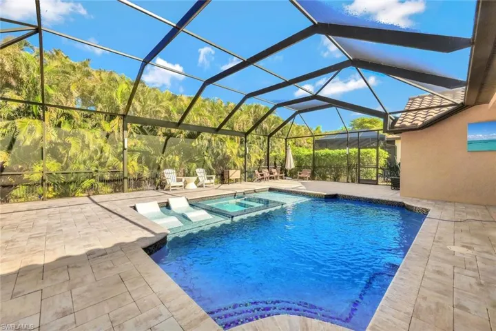 View of swimming pool featuring an in ground hot tub, a lanai, and a patio area