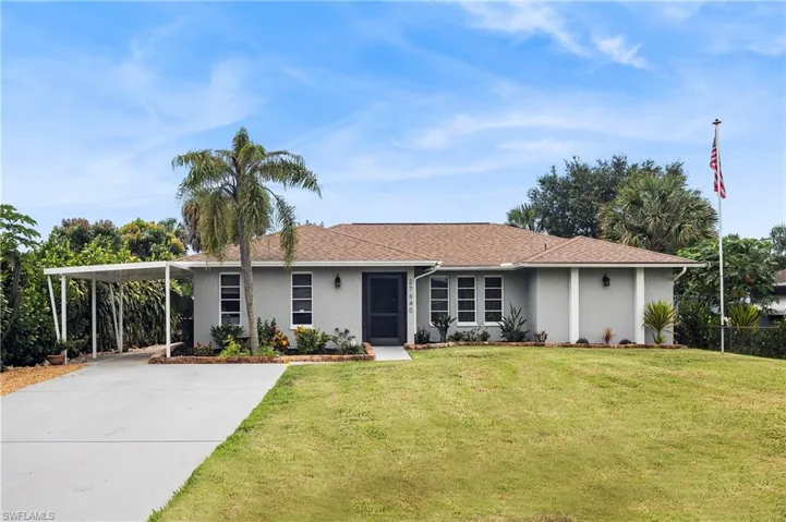 Ranch-style home featuring a front yard and a carport