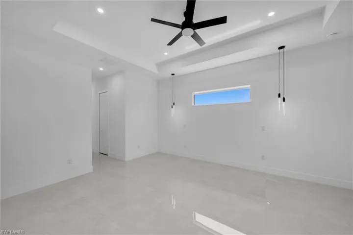 Spare room featuring recessed lighting, a raised ceiling, a ceiling fan, visible vents, and baseboards