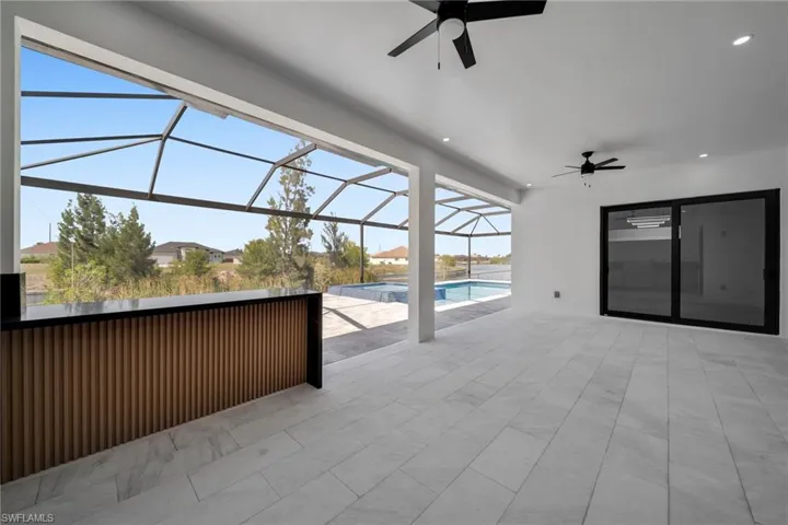View of patio / terrace featuring a lanai, ceiling fan, and a pool with connected hot tub