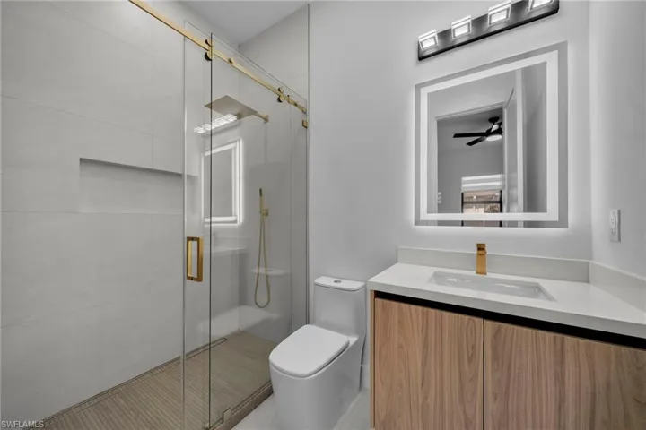 Bathroom with vanity, toilet, and a shower stall