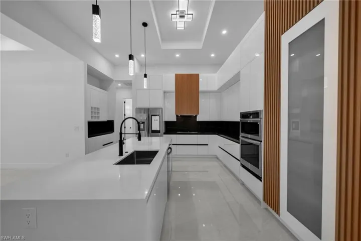Kitchen featuring white cabinetry, a sink, appliances with stainless steel finishes, recessed lighting, and modern cabinets