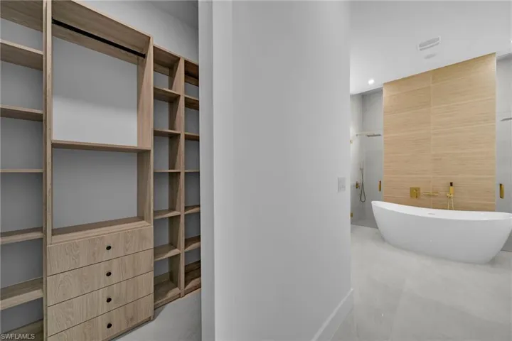 Bathroom featuring tile walls, a freestanding tub, and recessed lighting