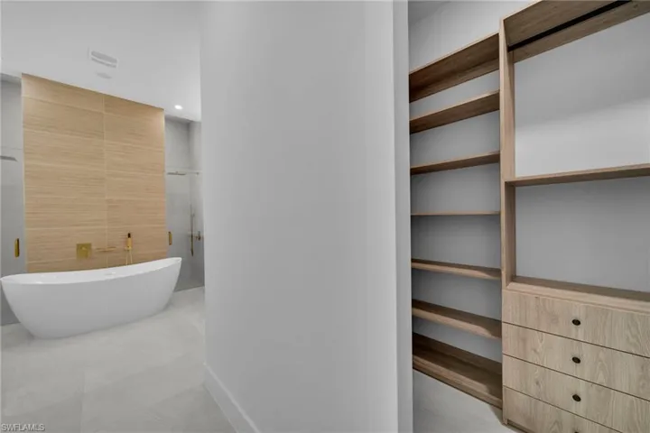 Full bath featuring a freestanding tub, a shower with shower door, recessed lighting, and tile walls