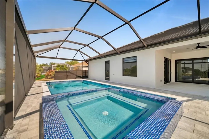 View of swimming pool with a lanai, ceiling fan, a patio, and a pool with connected hot tub