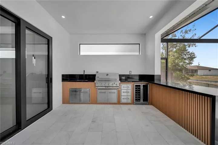 Kitchen featuring a sink, beverage cooler, dark countertops, recessed lighting, and modern cabinets