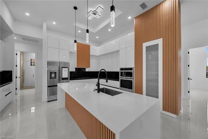 Kitchen with a sink, modern cabinets, visible vents, white cabinetry, and appliances with stainless steel finishes