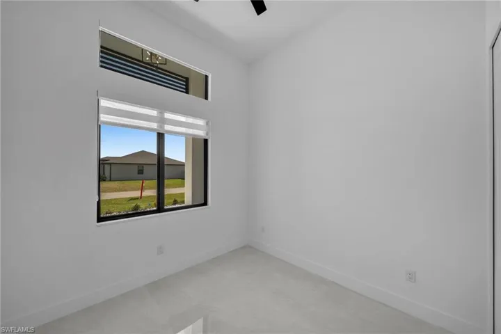 Unfurnished room with a ceiling fan and baseboards