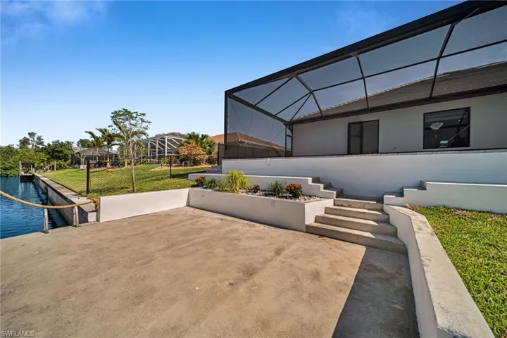View of patio with a lanai and a water view