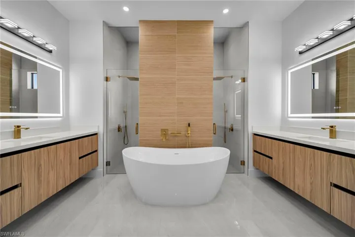 Full bathroom with two vanities, a shower stall, and a sink