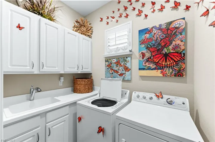 Laundry area featuring separate washer and dryer and cabinet space