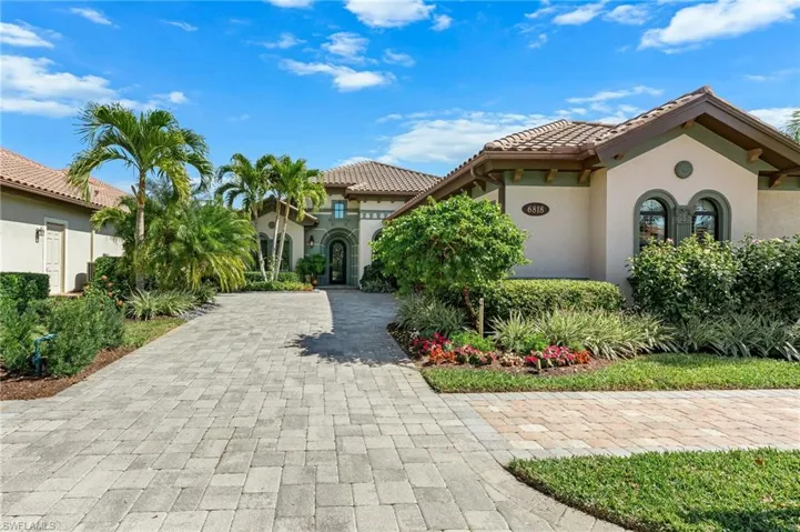 View of front facade with stucco siding, decorative driveway, and a tile roof