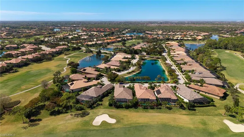 Aerial view of residential area featuring a golf club and a nearby body of water