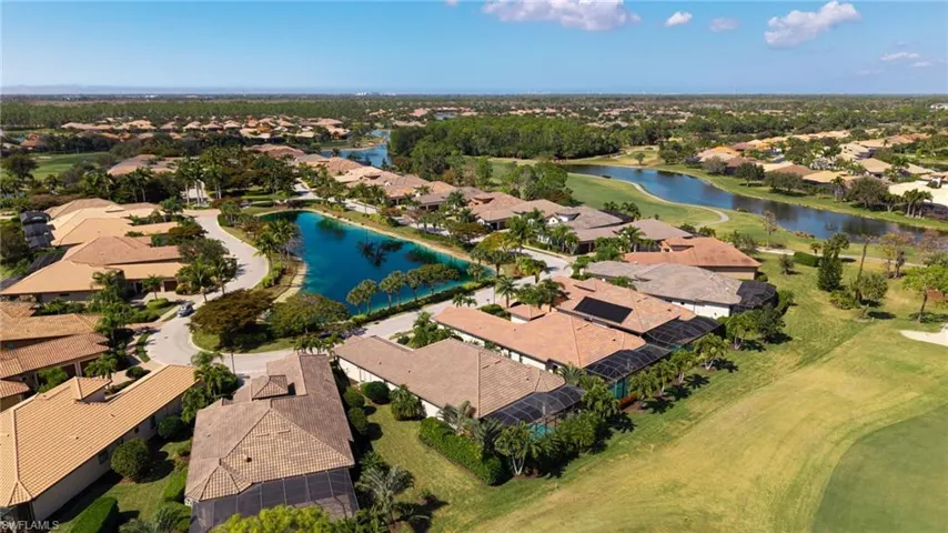Aerial view of residential area featuring a large body of water and a golf course