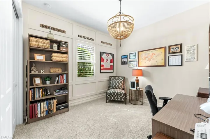 Carpeted office space with suspended lighting and a decorative wall