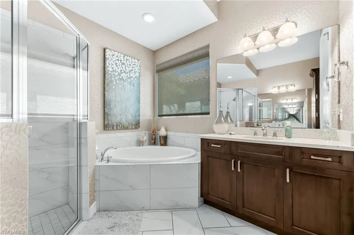 Full bath with a shower stall, a garden tub, and vanity