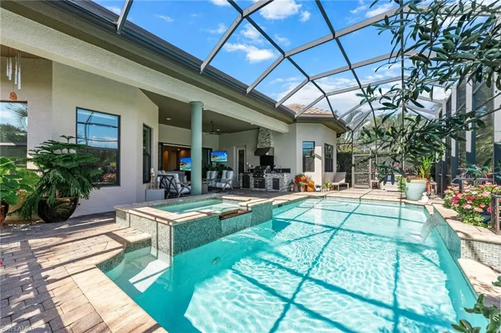 Integrated pool / spa featuring a patio area, a sunroom, a lanai, and area for grilling